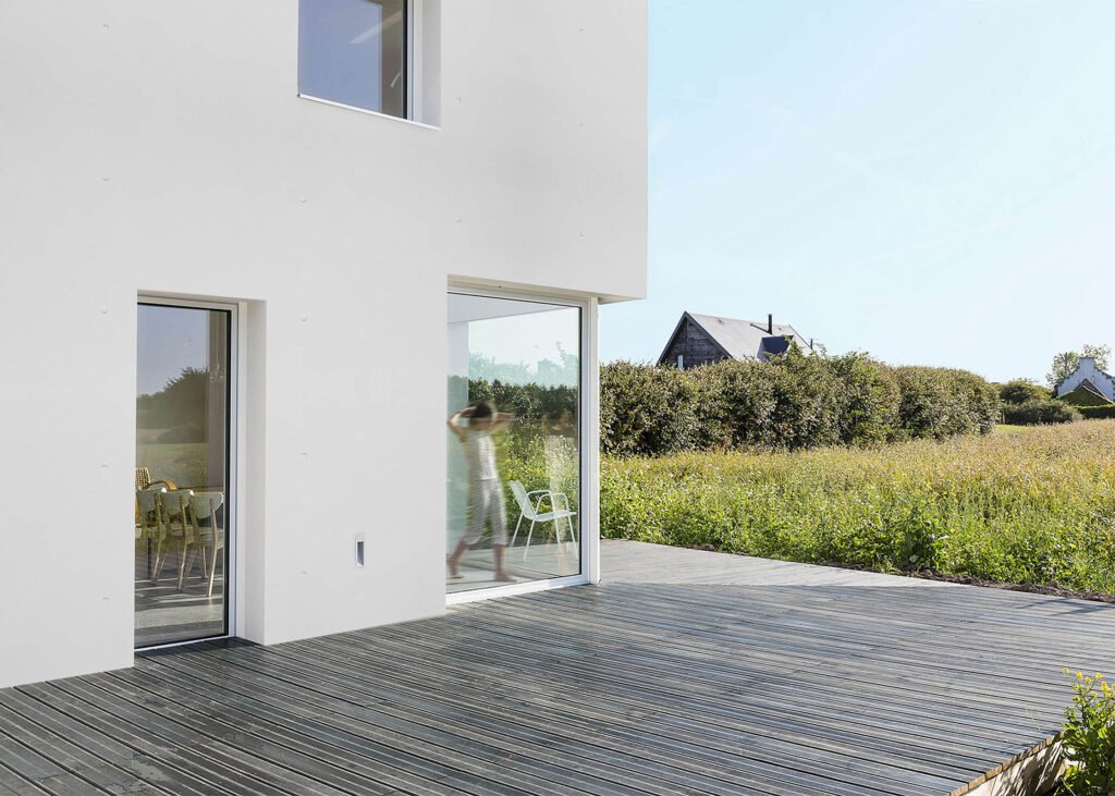 Grey White wall concrete panels on a modern building exterior with glass doors and windows